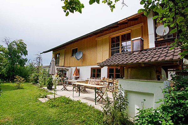 Gemütliches Einfamilienhaus mit Holzbalkon, Terrasse und großem Garten im Grünen.